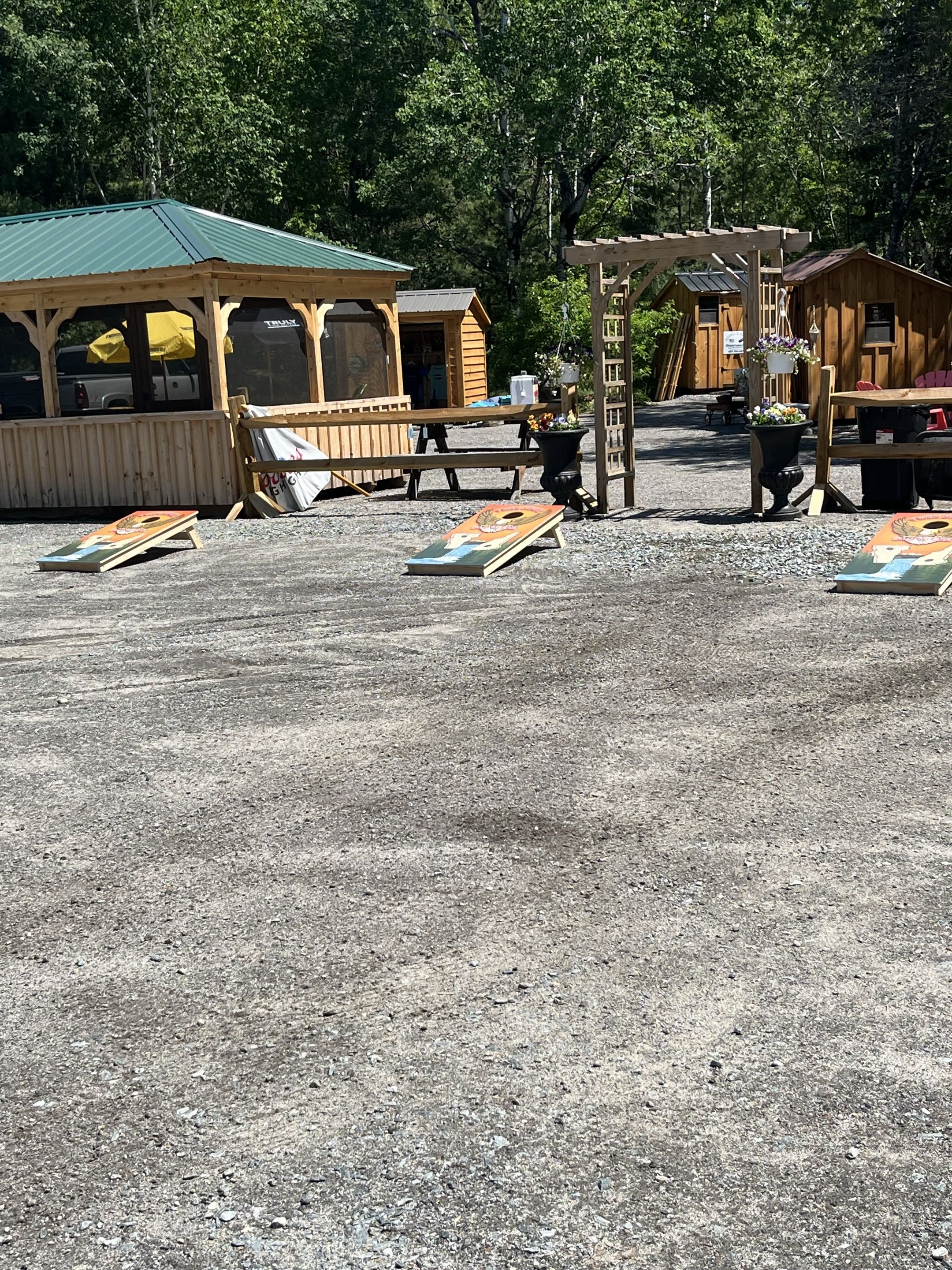 Cornhole boards set up with gazebo and cabins